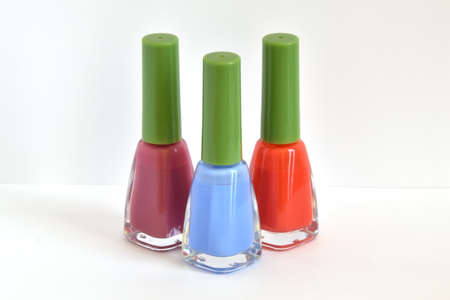 Three similar bottles of different nail polish on white background.の写真素材
