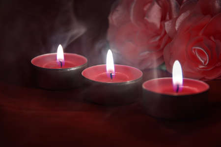 Romantic card with beautiful red candles, smoke and roses in the darknessの写真素材