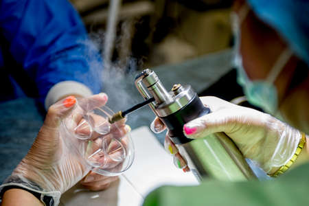 The doctor makes the patient cryotherapy procedure. Close-up of the patient's hand and wounded...