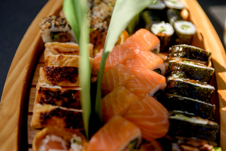 Appetizing sushi close-up. Maki and rolls with tuna, salmon, shrimp, crab and avocado. Top view of a variety of sushi on a wooden stand.の写真素材