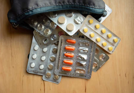 Close-up blisters with pills fall out of the medicine chest. Many blisters with different pills on a...