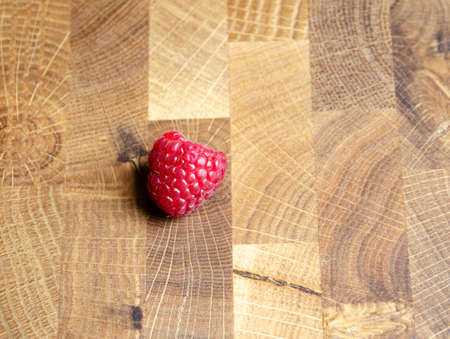 Close-up raspberry on wooden background with copy space. Sweet raspberry on wooden table. Close up, top view, selective focus. Harvest Concept. Fresh raspberry on a brown wooden surface.の写真素材