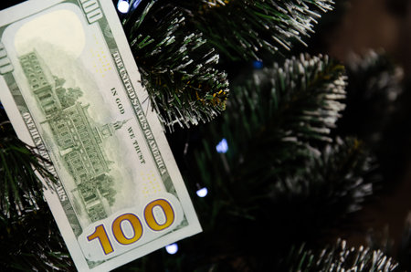 Christmas tree decorated with money. Dollar banknote as Christmas tree toy. Rich year concept. Best...