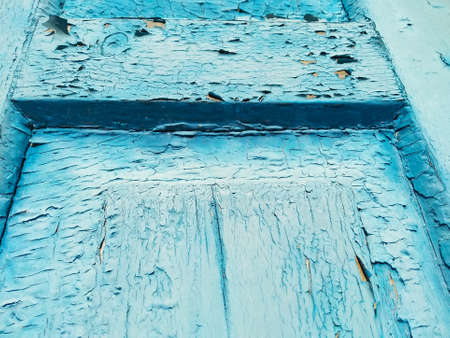 Close-up old blue cracked paint. The texture of the old emerald paint with cracks. Dried in the sun...