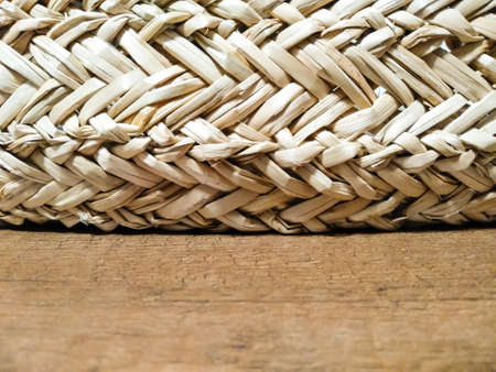 Selective focus straw decor lies on wooden table. The texture of straw pots and wooden surface. Home...