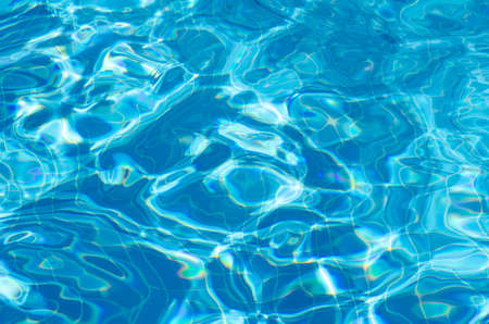 Hotel pool with sun reflections. Summer vacation concept. Surface of azure swimming pool. Top view rippled blue pool water with copy space.の写真素材