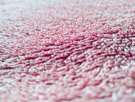 Macroshot texture of red terry cloth with copy space. Selective focus surface of fuzzy towel. Things for home use.の写真素材