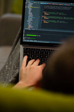 London, UK - January 12, 2022. Caucasian man uses MacBook Air M1. Programmer is coding on latest Apple laptop. Concept of modern popular professions. vertical photo.のeditorial素材
