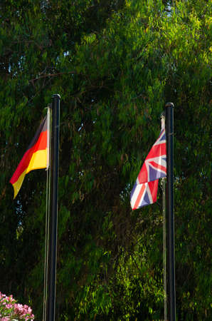 German flag and the Union Jack are waving in the wind on flagpoles. political situation between United Kingdom and Germany. The concept of international relations.の写真素材