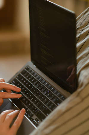 London, UK - January 12, 2022. Caucasian man uses MacBook Air M1. Programmer is coding on latest Apple laptop. Concept of modern popular professions. vertical photo.のeditorial素材