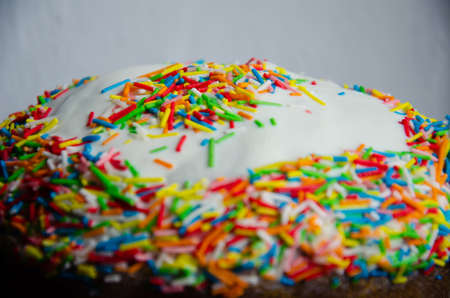 Traditional Easter cake decorated with icing and multicolored decor. Traditional sweets for the Christian holiday. Festive background with copy space.の写真素材