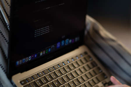London, UK - January 12, 2022. Caucasian man uses MacBook Air M1. Programmer is coding on latest Apple laptop. Concept of modern popular professions. vertical photo.のeditorial素材
