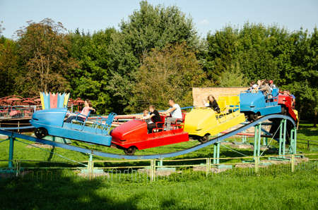 Lutsk, Ukraine - August 18, 2021. Old amusement park for children and adults. People have fun on old metal rides. Family vacation in the city. fun concept.のeditorial素材