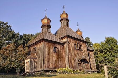 History. Ancient wood Christianity church in the summer meadowの写真素材