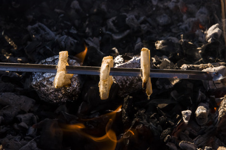 Cooking on the nature. Roasting tasty bacon on the brazier with bonfire and coalの写真素材