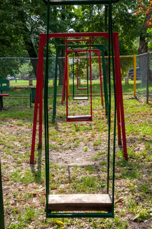 Children's playground on the yard in summer. Rest with little child. swing in the park