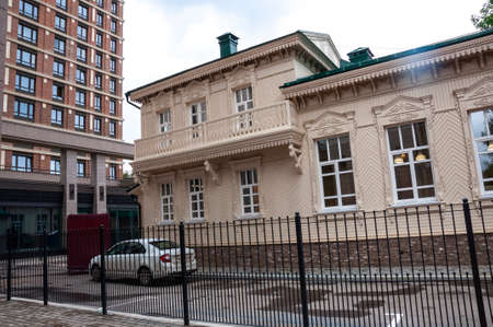 Ancient historical profitable carved houses made of wood are located on the streets of the modern cityの写真素材