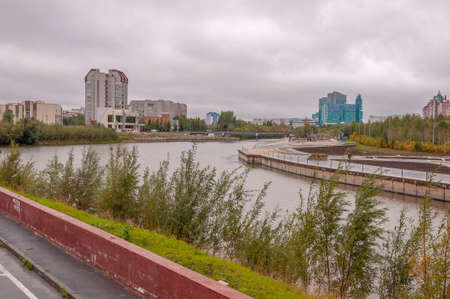 Surgut, Russia, 12 Griboyedov Street, May 11, 2022. Modern buildings and view of the embankment of...