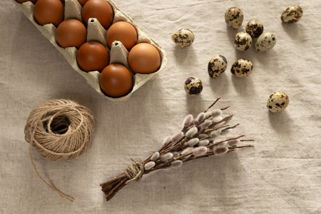 Easter eggs and willow twigs on a linen tablecloth