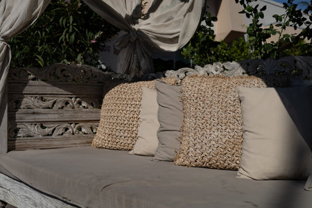 Wicker sofa with pillows on the terrace in the garden