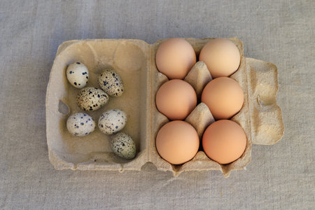 Eggs in a cardboard box on a linen tablecloth.