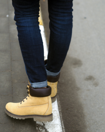 Girl in beautiful yellow winter shoes on the street