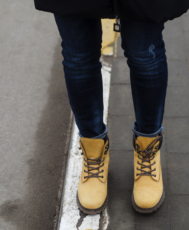 girl in beautiful yellow winter shoes  on the streetの写真素材