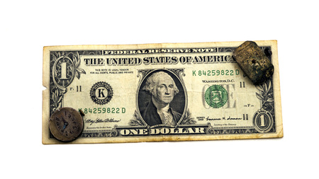 The old dilapidated clock is located on one dollar. Isolated on white background. Concept time is money.の写真素材
