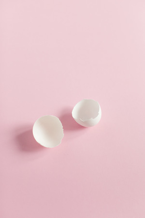 White Easter eggs on a light pink background, colored decorations, minimalistic design, vertical shotの写真素材