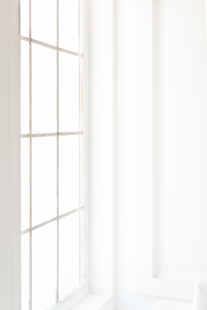 Light minimalist laconic interior with white walls, large windows. Daylight, vertical shot.の写真素材