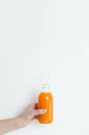 Morning breakfast, table setting. On a white plate are two fried eggs, on a wooden board sliced avocado, a cup of coffee and a vase with a plant. White background, daylight, vertical image.の写真素材