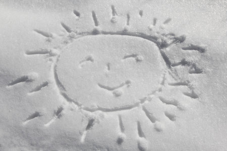 Sun drawn on snowの写真素材