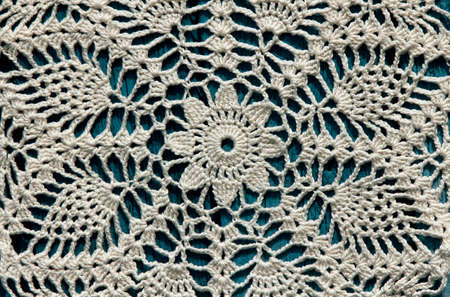 Beautiful crochet doily on blue wooden background