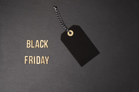 Black background and black price label.  Black Friday. Sales concept. Copy space.  Black paper label against a dark grey background. Black Friday shopping sale concept with Black ticket Sale tag close up on black background.の写真素材