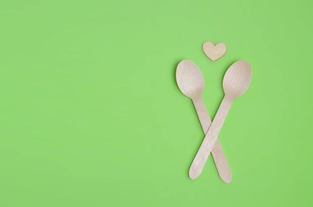 Disposable tableware from natural materials, wooden spoon, Eco-friendly. Wooden spoons Eco concept on green background. Copy space. Eco pine wood spoons.の写真素材