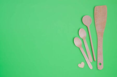 Disposable tableware set from natural materials, wooden spoon, Eco-friendly. Wooden spoons Eco concept on green background. Copy space. Eco pine wood spoons.の写真素材
