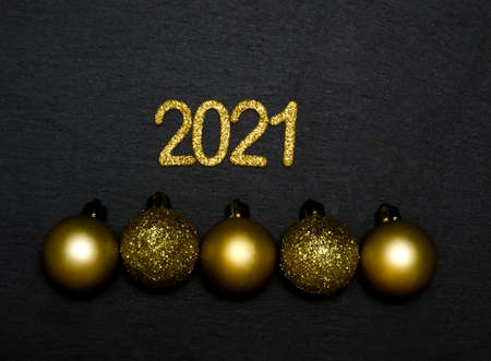 Happy New year 2021. Golden digits 2021 with golden Christmas balls flat lay with copy space on...