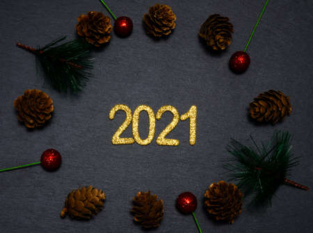 Happy New year 2021. Golden digits 2021 flat lay with copy space on black background. 2021 numbers with Christmas natural decorations.の写真素材