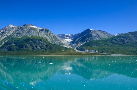 Alaska landscape mountains and water and blue sky. Mountains reflection in the water. Remote location, unplugged. Wild beauty in nature. Untouched environmentの写真素材