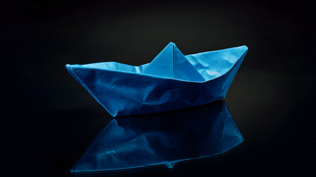 Paper boat on a black background and reflectionの素材