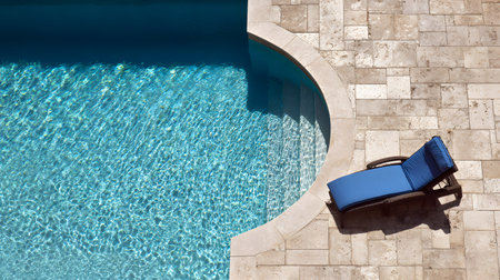 Aerial view of a beach chair by the swimming pool with sunlight and shadow at a luxury hotel resort. sun loungers and umbrellas. Summer vacation conceptの素材