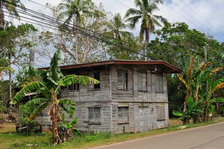 A typical two-storied wooden house is built close to the municipal road, Danao, Panglao, Philippinesの写真素材