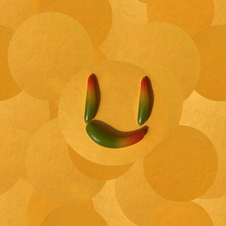 Letter U assembled with small bell peppers on the warm background of yellow, gold, and orange overlapping circles creating a seamless pattern; a square mixed-media artwork.の写真素材