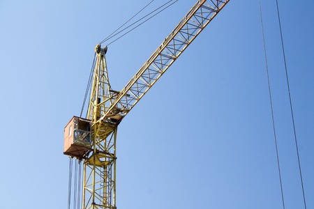 Photo of construction crane against a blue sky background.