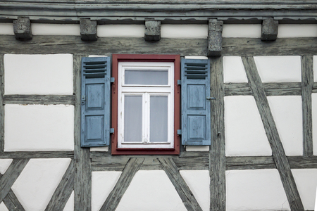 Old ancient wooden window with blinds or shutters. Scenic original and colorful view of antique...
