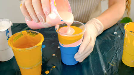 Fluid art technique. Female artist works on abstract fluid art painting.の写真素材