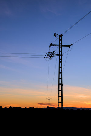 Silhouette of an electric pole on dusk background.の写真素材