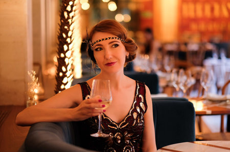 Woman in 1920 style clothes with a glass.の写真素材