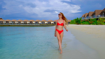 Woman in a bikini is walking. Female is happy on Maldives.の写真素材