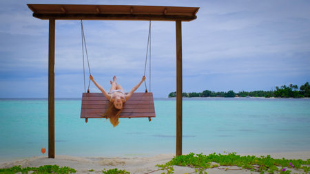 Woman in a bikini is on swings.の写真素材